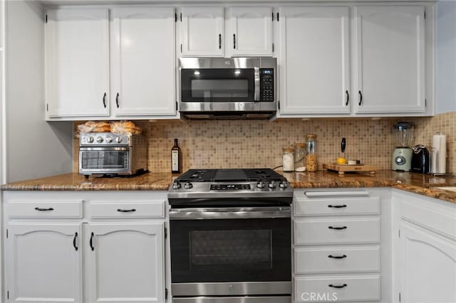 42821 15th St W Unit 4, Lancaster, CA 93534 - kitchen with appliances with stainless steel finishes, white cabinets, backsplash, and dark stone countertops