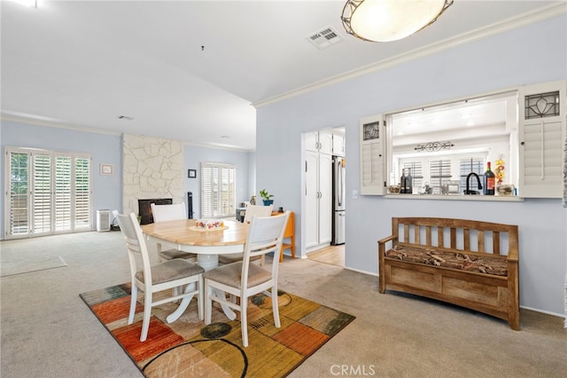 42821 15th St W Unit 4, Lancaster, CA 93534 - carpeted dining area with crown molding, healthy amount of natural light, and a stone fireplace
