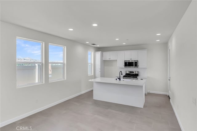 7408 Desert Sky Dr, Yucca Valley, CA 92284 - kitchen with stainless steel microwave, stove, white cabinets, light countertops, and recessed lighting