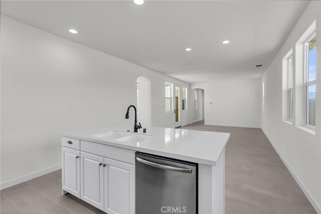 7408 Desert Sky Dr, Yucca Valley, CA 92284 - kitchen with dishwasher, arched walkways, white cabinets, light countertops, and a center island with sink