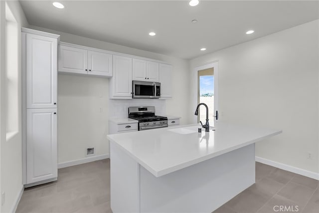 7408 Desert Sky Dr, Yucca Valley, CA 92284 - kitchen featuring appliances with stainless steel finishes, white cabinetry, an island with sink, light countertops, and recessed lighting