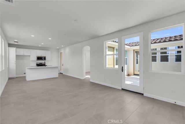 7408 Desert Sky Dr, Yucca Valley, CA 92284 - unfurnished living room featuring healthy amount of natural light, arched walkways, and recessed lighting