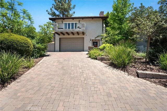 3532 Mesquite Dr, Calabasas, CA 91302 - mediterranean / spanish-style home with a balcony, decorative driveway, stucco siding, a chimney, and an attached garage