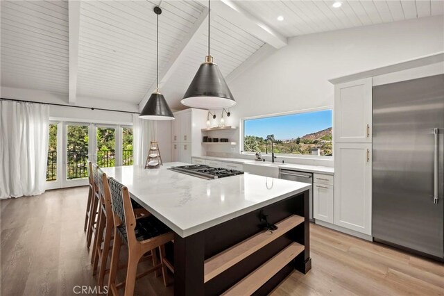 3532 Mesquite Dr, Calabasas, CA 91302 - kitchen featuring stainless steel appliances, open shelves, light wood finished floors, a center island, and light countertops