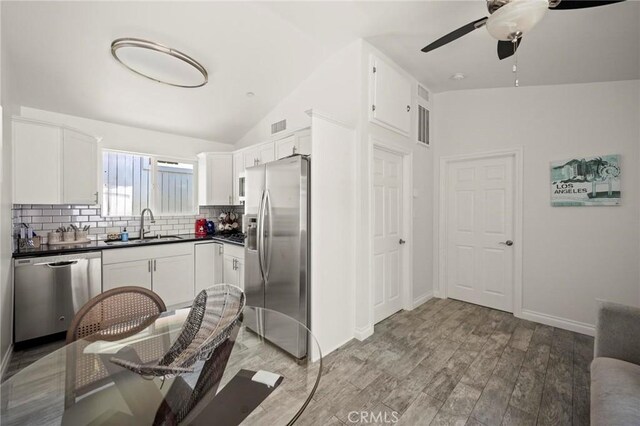 3532 Mesquite Dr, Calabasas, CA 91302 - kitchen with stainless steel appliances, dark countertops, backsplash, ceiling fan, and lofted ceiling