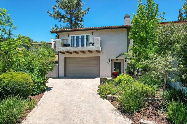 3532 Mesquite Dr, Calabasas, CA 91302 - mediterranean / spanish-style home with a balcony, stucco siding, a chimney, and a garage