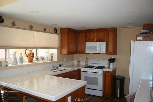 44535 Aspen St, Lancaster, CA 93535 - kitchen with white appliances, a peninsula, brown cabinetry, and dark wood-type flooring