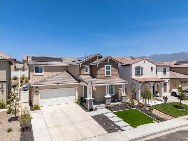 554 Cumberland Rd, Rialto, CA 92377 - view of front of home featuring a tiled roof, stucco siding, driveway, covered porch, and solar panels