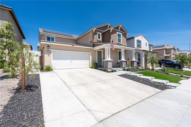 554 Cumberland Rd, Rialto, CA 92377 - view of front of property with a porch, concrete driveway, roof mounted solar panels, and stucco siding