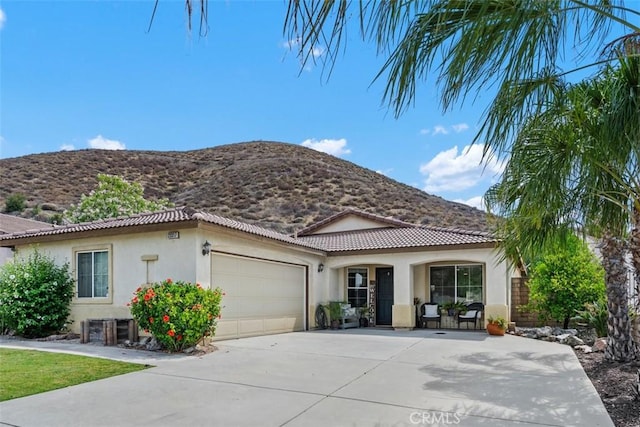 23317 Badger Creek Ln, Menifee, CA 92587 - mediterranean / spanish-style house with stucco siding, a mountain view, a garage, and driveway