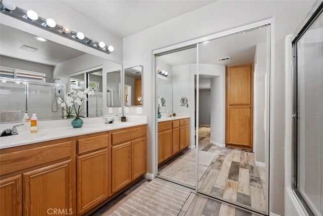 23317 Badger Creek Ln, Menifee, CA 92587 - bathroom with wood finished floors, a shower with shower door, and double vanity