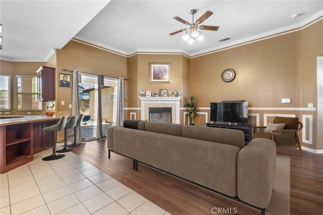 2802 Silver Shore Ln, Bakersfield, CA 93313 - living room with ceiling fan, wood finished floors, crown molding, and a tiled fireplace