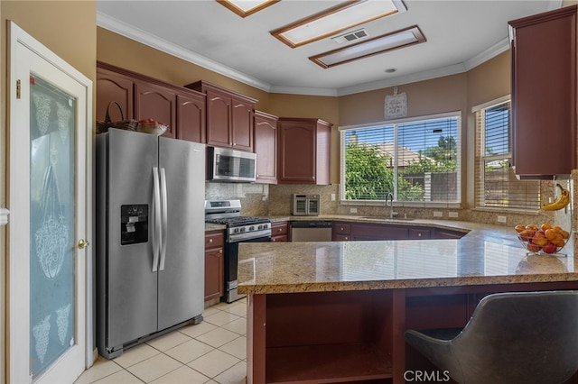 2802 Silver Shore Ln, Bakersfield, CA 93313 - kitchen featuring stainless steel appliances, a peninsula, light tile patterned floors, tasteful backsplash, and ornamental molding