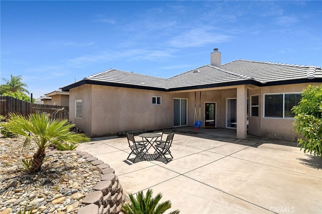 2802 Silver Shore Ln, Bakersfield, CA 93313 - rear view of house with stucco siding, a chimney, a patio area, and a tile roof