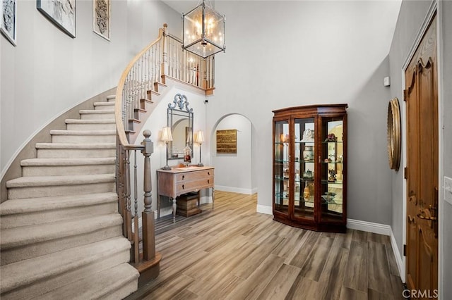 1624 Alessandro Rd, Redlands, CA 92373 - entryway with stairs, wood finished floors, a chandelier, a high ceiling, and arched walkways