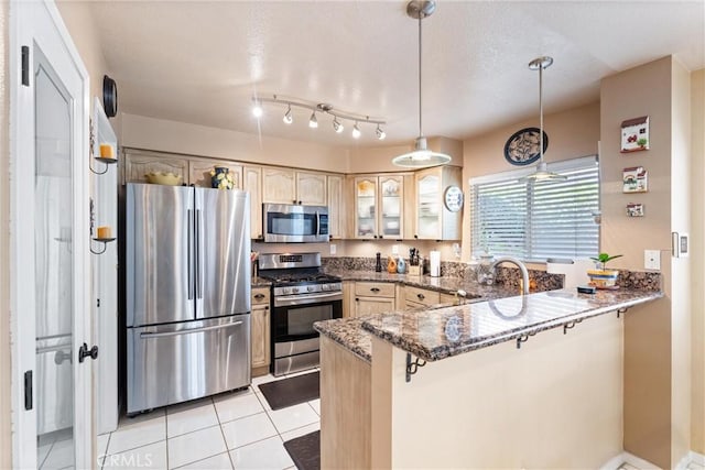 861 Shade Tree Way, Corona, CA 92878 - kitchen featuring stainless steel appliances, a peninsula, glass insert cabinets, dark stone counters, and hanging light fixtures