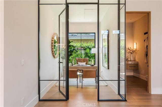 16711 Moorpark St, Encino, CA 91436 - doorway to outside featuring wood finished floors and baseboards