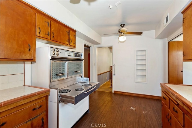 8356 Duarte Rd, San Gabriel, CA 91775 - kitchen with tile counters, oven, ceiling fan, brown cabinets, and backsplash