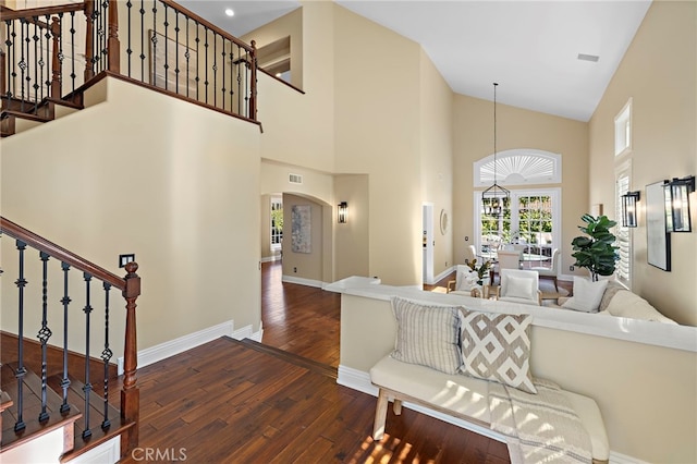 42 Fairlane Rd, Laguna Niguel, CA 92677 - living room with wood finished floors, arched walkways, high vaulted ceiling, and stairway