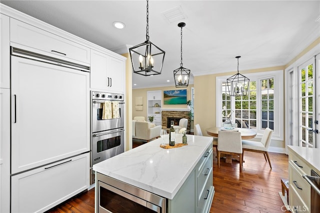 42 Fairlane Rd, Laguna Niguel, CA 92677 - kitchen with built in appliances, a chandelier, crown molding, dark wood-style floors, and a fireplace