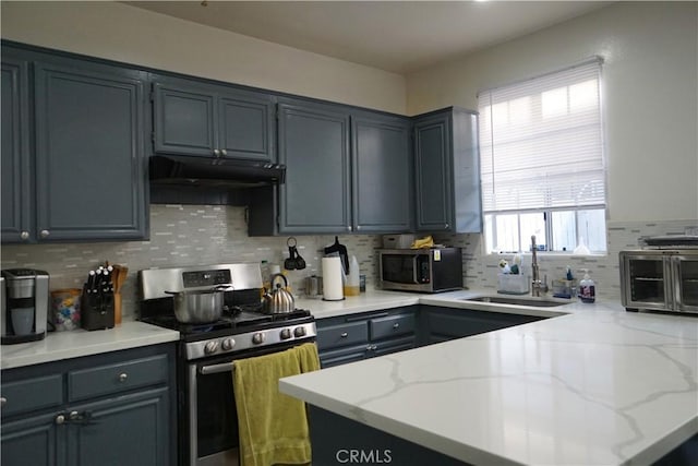 18347 Saticoy St Unit 33, Reseda, CA 91335 - kitchen with appliances with stainless steel finishes, decorative backsplash, a peninsula, and light stone counters