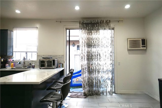 18347 Saticoy St Unit 33, Reseda, CA 91335 - kitchen featuring plenty of natural light, recessed lighting, a breakfast bar, backsplash, and light stone countertops