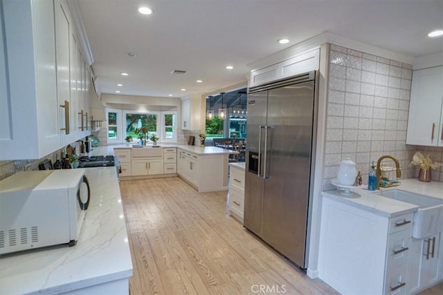 10624 Nevada Ave, Chatsworth, CA 91311 - kitchen with built in fridge, white microwave, tasteful backsplash, light stone countertops, and recessed lighting