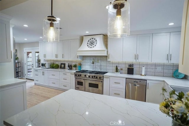 10624 Nevada Ave, Chatsworth, CA 91311 - kitchen featuring appliances with stainless steel finishes, custom range hood, backsplash, light stone countertops, and white cabinetry