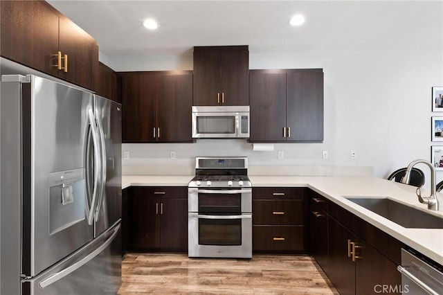 5 Zacate St, Rancho Mission Viejo, CA 92694 - kitchen featuring stainless steel appliances, light countertops, dark brown cabinetry, light wood-type flooring, and recessed lighting
