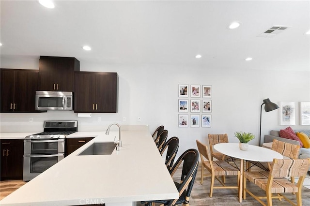 5 Zacate St, Rancho Mission Viejo, CA 92694 - kitchen with stainless steel appliances, a peninsula, light countertops, light wood-style floors, and recessed lighting