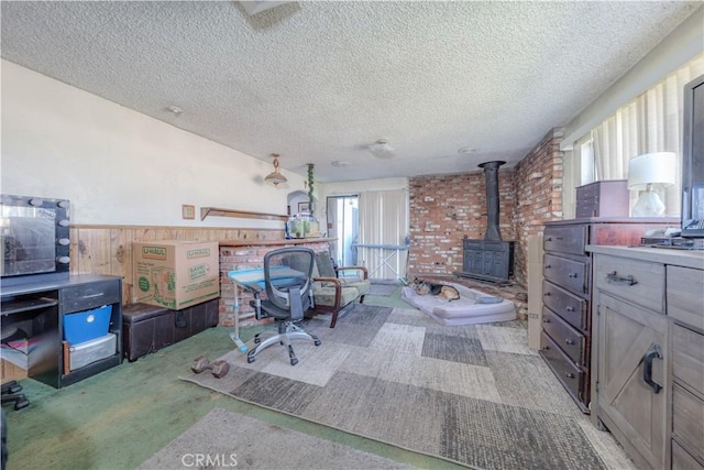 13572 Sutter Dr, Westminster, CA 92683 - home office featuring a wood stove, light colored carpet, a textured ceiling, wood walls, and a wainscoted wall