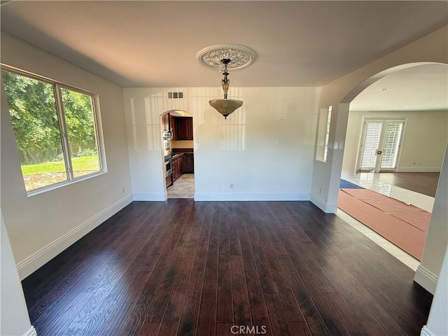 11737 Lois Ct, Granada Hills, CA 91344 - unfurnished dining area with arched walkways and dark wood-style floors