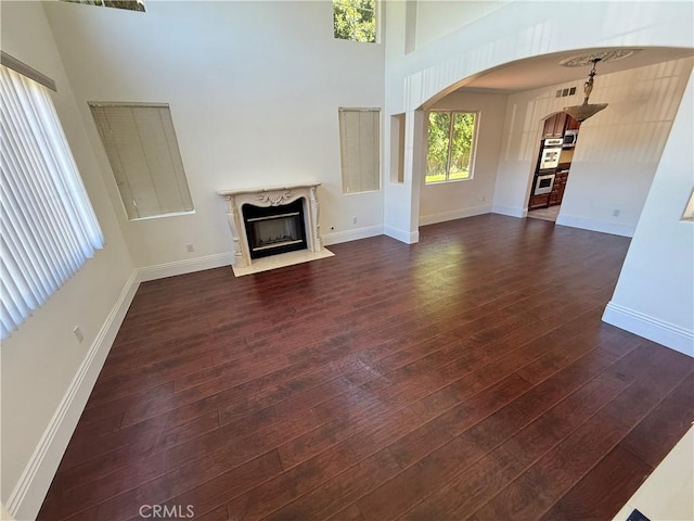 11737 Lois Ct, Granada Hills, CA 91344 - unfurnished living room featuring arched walkways, dark wood-style flooring, and a high end fireplace