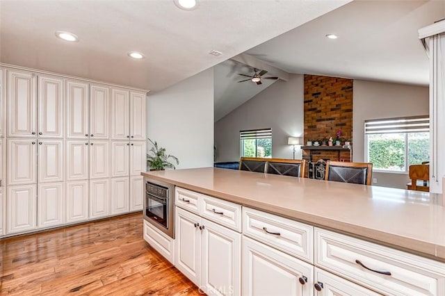 2580 Crown Way, Fullerton, CA 92833 - kitchen with lofted ceiling, ceiling fan, light wood-style flooring, plenty of natural light, and white cabinets