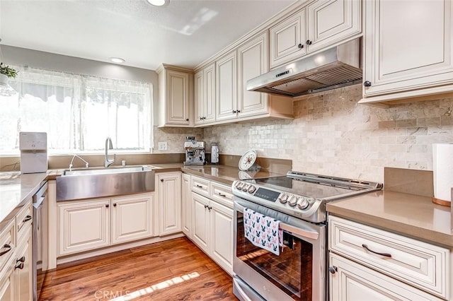 2580 Crown Way, Fullerton, CA 92833 - kitchen featuring appliances with stainless steel finishes, under cabinet range hood, light wood-style floors, backsplash, and recessed lighting
