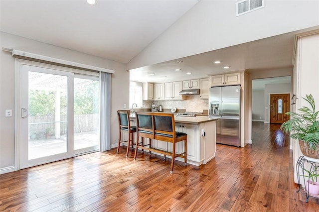 2580 Crown Way, Fullerton, CA 92833 - kitchen with stainless steel refrigerator with ice dispenser, under cabinet range hood, a peninsula, hardwood / wood-style floors, and a breakfast bar