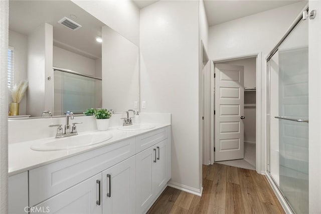 247 Lockhart Way, West Covina, CA 91790 - bathroom featuring wood finished floors, a stall shower, double vanity, and a spacious closet