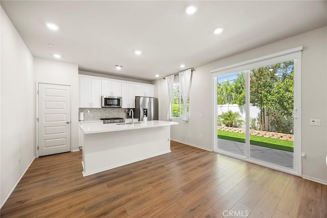 247 Lockhart Way, West Covina, CA 91790 - kitchen with stainless steel appliances, an island with sink, light countertops, white cabinets, and wood finished floors