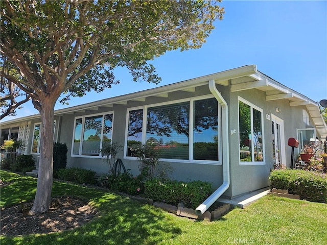 1402 Golden Rain Rd Unit 55G, Seal Beach, CA 90740 - view of side of home featuring stucco siding and a lawn