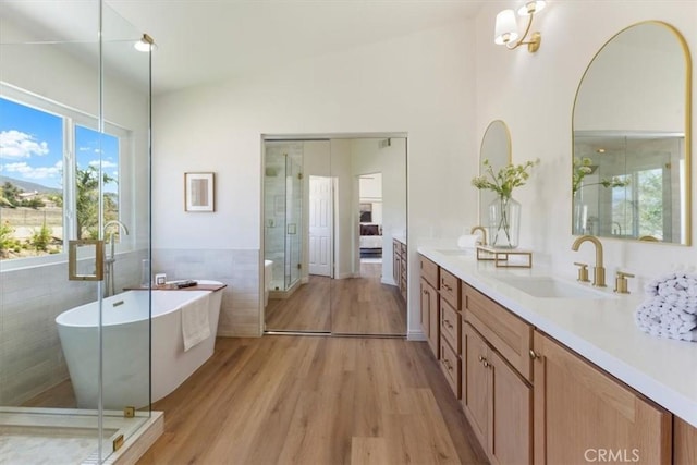 14080 Crestline Pl, Rancho Cucamonga, CA 91739 - bathroom with tile walls, double vanity, wood finished floors, a freestanding tub, and a stall shower