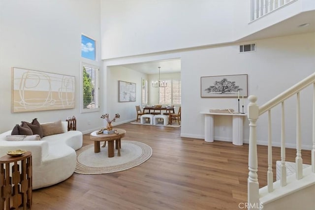 14080 Crestline Pl, Rancho Cucamonga, CA 91739 - living room featuring a towering ceiling, healthy amount of natural light, wood finished floors, stairs, and a chandelier
