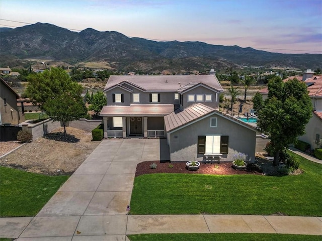 14080 Crestline Pl, Rancho Cucamonga, CA 91739 - view of front facade with stucco siding, driveway, a mountain view, a porch, and a standing seam roof