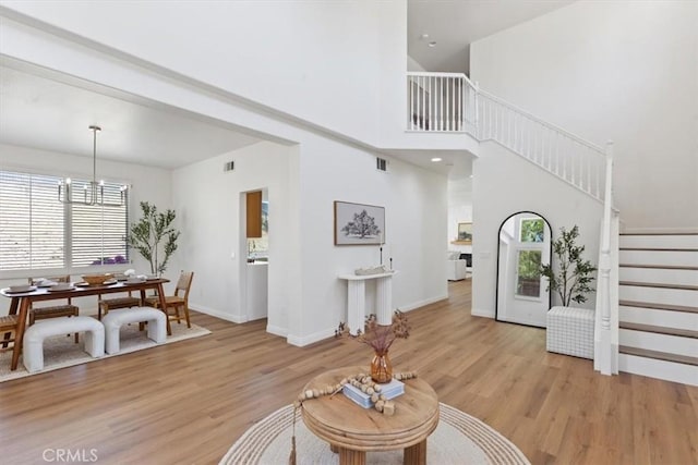 14080 Crestline Pl, Rancho Cucamonga, CA 91739 - living area with stairway, healthy amount of natural light, light wood-style floors, a chandelier, and a high ceiling