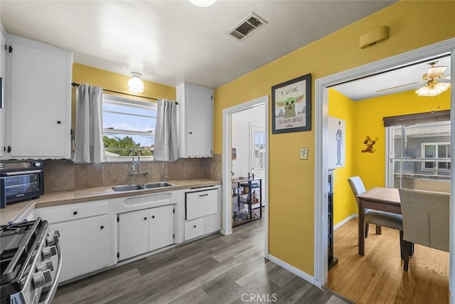 2184 S Towne Ave, Pomona, CA 91766 - kitchen with stainless steel gas range, wood finished floors, light countertops, white cabinets, and decorative backsplash