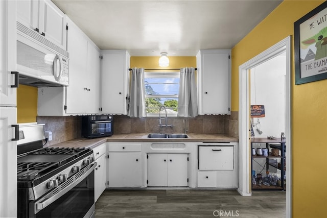 2184 S Towne Ave, Pomona, CA 91766 - kitchen featuring white microwave, stainless steel range with gas stovetop, white cabinetry, and dark wood finished floors