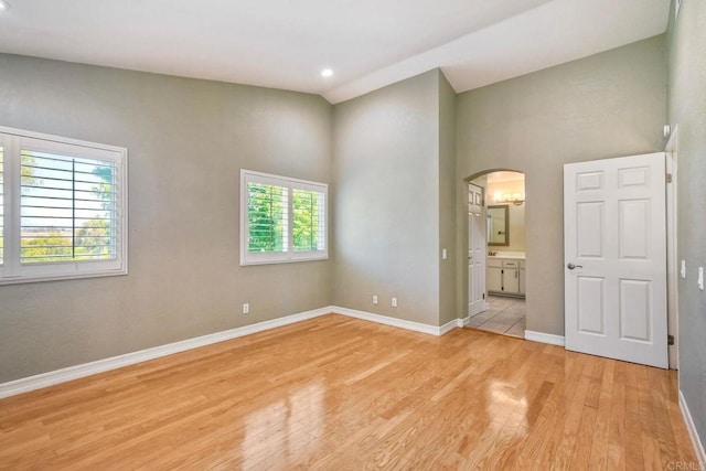 635 Boysenberry Way, Oceanside, CA 92057 - unfurnished bedroom featuring light wood finished floors, arched walkways, connected bathroom, high vaulted ceiling, and recessed lighting