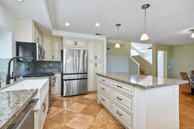 635 Boysenberry Way, Oceanside, CA 92057 - kitchen with stainless steel appliances, backsplash, pendant lighting, light stone counters, and a center island