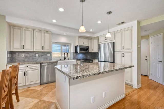 635 Boysenberry Way, Oceanside, CA 92057 - kitchen with stainless steel appliances, backsplash, light stone counters, a center island, and recessed lighting