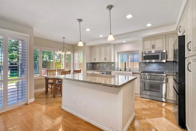 635 Boysenberry Way, Oceanside, CA 92057 - kitchen with appliances with stainless steel finishes, tasteful backsplash, a kitchen island, light stone countertops, and recessed lighting