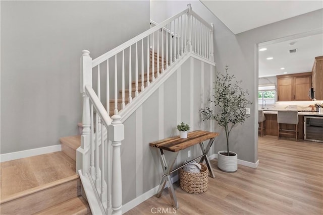 9180 Araujo Ct, Atascadero, CA 93422 - staircase with wine cooler, wood finished floors, and recessed lighting